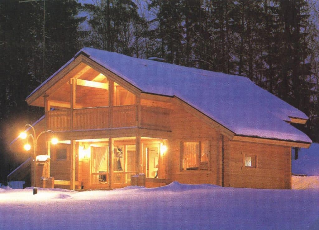 Ein Holzblockhaus mit Schleppdach und Balkon im Winter mit Schnee
